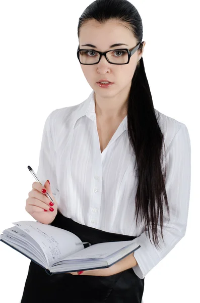 Business woman holding a pen and notebook and flirty looks ahead. Isolated on white. — Stok fotoğraf
