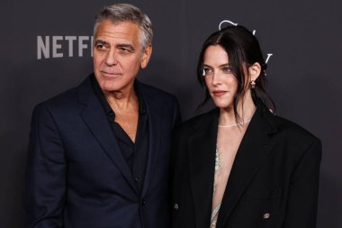 Amerikalı aktör, film yapımcısı, aktivist ve insancıl George Clooney ve Amerikan aktris Riley Keough, 11 Kasım 2025 'te Hollywood, Los Angeles' ta düzenlenen Netflix 'in Jay Kelly filminin Los Angeles galasına geldiler.  