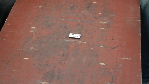 Homme jouant dominos sur le dessus de table rugueux — Video