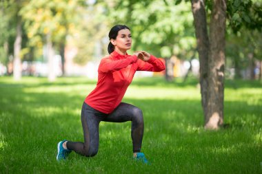 Şehir parkında bacak egzersizi yapan bir kadın. Bacaklara hücum..