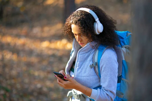 Portrait en gros plan d'une femme afro-américaine, perdue dans la forêt. Perdu dans la forêt et en utilisant l'application GPS dans le téléphone mobile — Photo