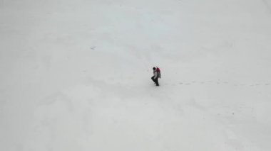 Kar tarlasında yürüyen bir insan. Havadan üst görünüm.
