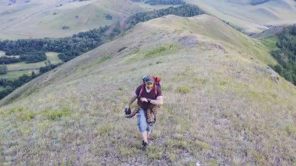 Luchtfoto van een mens die over een heuveltop loopt. — Stockvideo