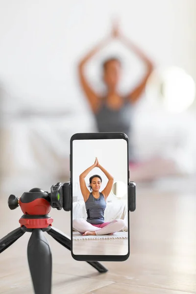 Yoga online to live streaming on a smartphone - vertical photo.