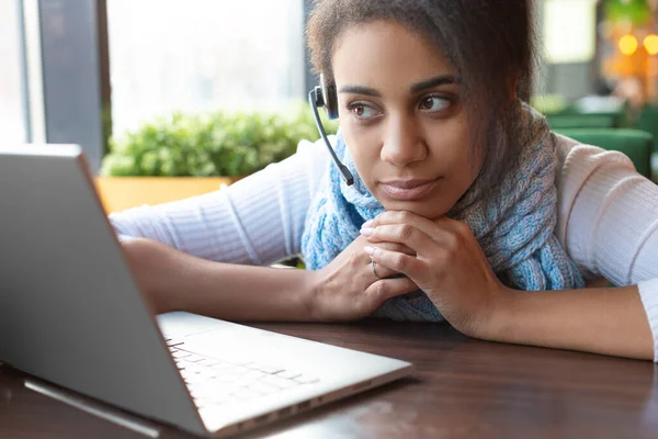 Pensive afro-amerikai fiatal nő előtt egy laptop monitor, miközben beszél online. — Stock Fotó