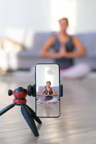 Online yoga lesson on a smartphone - fitness trainer teaches exercise so that the audience via the Internet.