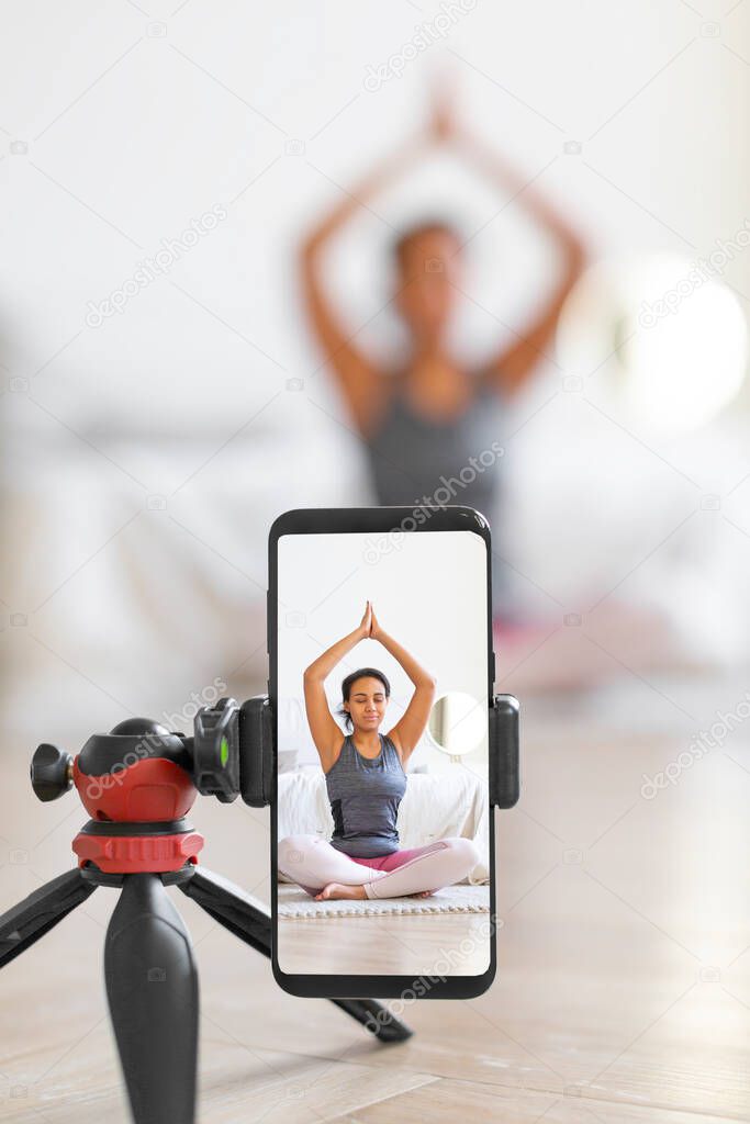 Yoga online to live streaming on a smartphone - vertical photo.