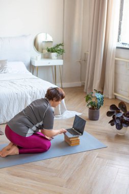 Son sınıf öğrencisi internetten pilates eğitimi almak istiyor. Dikey fotoğraf.