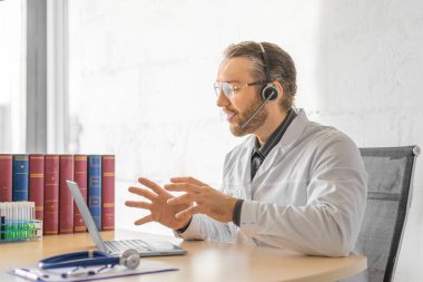 İnternette bir hastayla görüşürken orta yaşlı bir doktor..