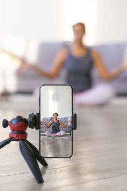 Akıllı telefondan canlı yayında yoga dersi. Dikey fotoğraf.