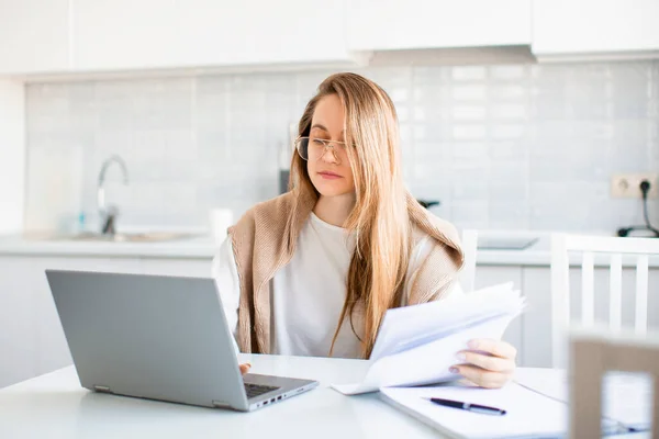 Mulher trabalha on-line na frente de um monitor de laptop. Preenche formulários fiscais ou paga contas.. — Fotografia de Stock