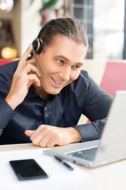 Çevrimiçi video görüşmesi sırasında gülümseyen orta yaşlı bir adamın portresi.