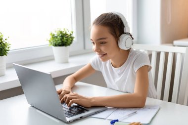Laptop monitörünün önündeki öğrenci kız. İnternetten ödevini yapıyor..