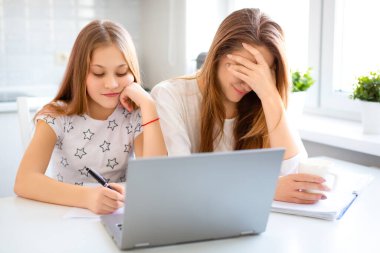 Anne, kızının ödevini internet üzerinden yapmasına yardım ediyor. Annem kızlarının aptallığı yüzünden utançla yüzünü kapattı..