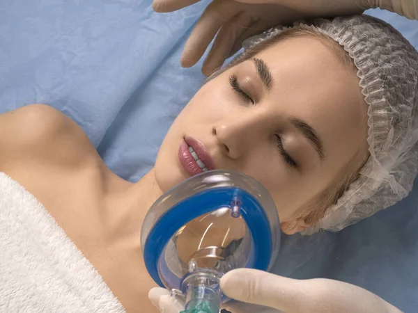 Doctor gives anesthesia to the patient before surgery or beauty procedure. Close-up photo.
