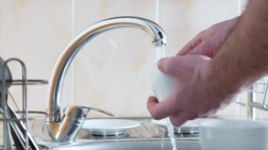 Erkek elleri sabah kahvesinden sonra bardakları yıkıyor..