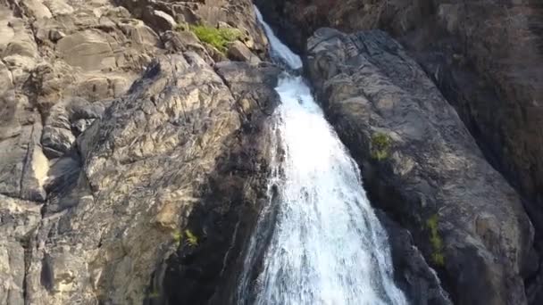 Vista de la cascada. El agua vierte sobre las rocas. La cámara se mueve hacia abajo - junto con el movimiento del agua — Vídeos de Stock