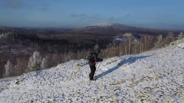 Osamělý poutník se vyšplhá na vrchol pohoří. Koncept cestování v extrémních podmínkách. Pohled shora. Dron úhlu pohledu. — Stock video