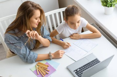 Dizüstü bilgisayarın önünde bir anne ve kızın en iyi görüntüsü..