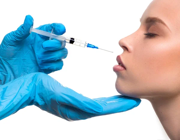 Skönhetsinjektioner. Närbild - handskar med en spruta injicerar Botox i läpparna. Operation för att korrigera läpparnas form. — Stockfoto