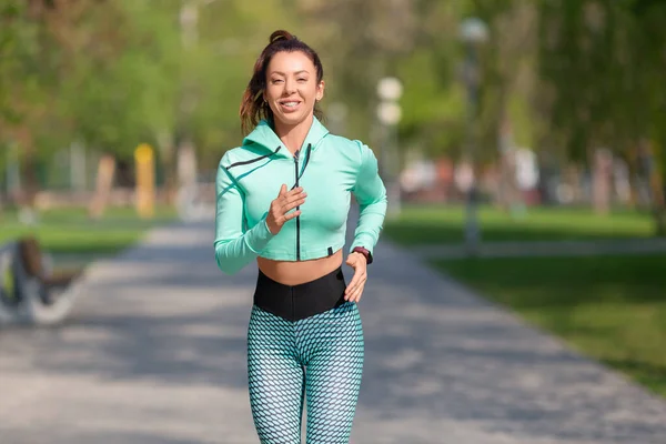 Imagen de una mujer corriendo en el parque temprano en la mañana. Mujer atractiva que se mantiene en forma y saludable. — Foto de Stock