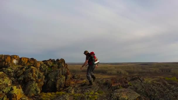 Flygfoto över en människa klättring till toppen av ett berg. Långsamma rörelser. — Stockvideo