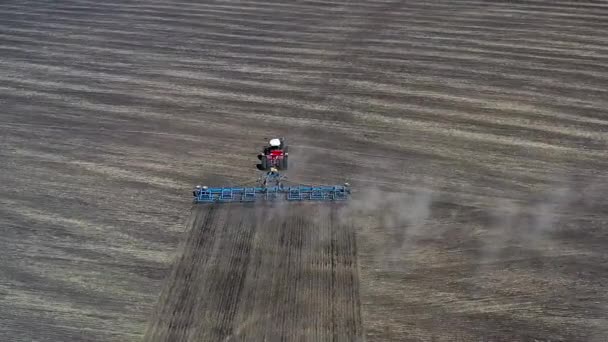 Pohled shora na červený traktor pěstující hnědou hlínu na slunném jaře, podzimní počasí. — Stock video