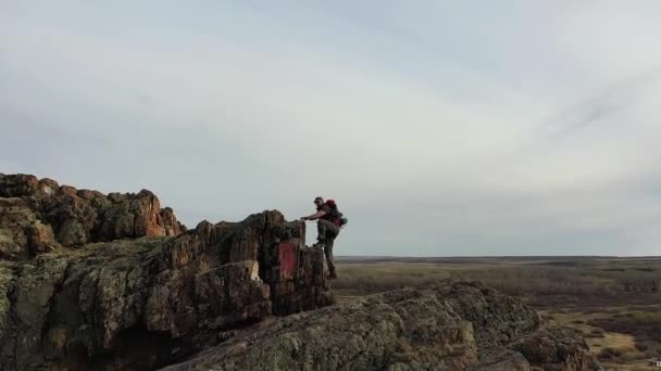 Un homme grimpant au sommet d'une montagne. — Video