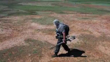 Ağır çekimde, yorgun asker-keskin nişancı kavurucu çölde yürüyor. Askeri çatışmalar ve olağanüstü koşullarda hayatta kalma kavramı..