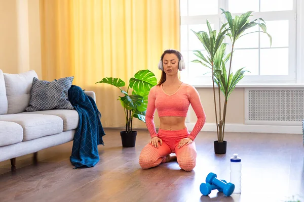 Kadın iç mekanda meditasyon yapıyor. Yoga egzersizleri yapmaya hazırlanıyor.. — Stok fotoğraf