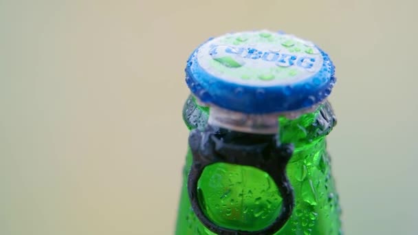 Čeljabinsk, Rusko - 10. června2021. Close up video - skleněná láhev Tuborg piva s nápisem TUBORG na korku. Chlazený nápoj s kapkami vody na skle a korku. — Stock video