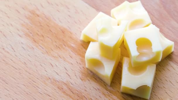 Vista superior: varios trozos de queso de leche aromático giran sobre un soporte de madera. — Vídeo de stock