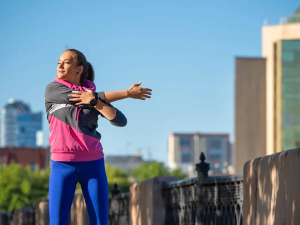 Mujer calentando. Ella estira sus músculos durante tu carrera matutina.. — Foto de Stock