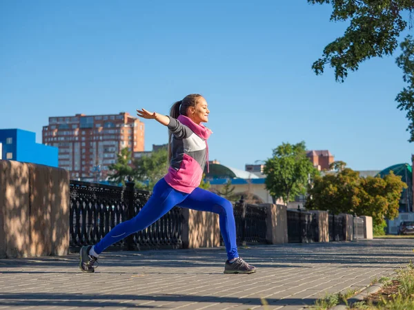 Mujer durante el entrenamiento de jogging matutino. Se pone el auricular en el oído y selecciona música para correr.. — Foto de Stock