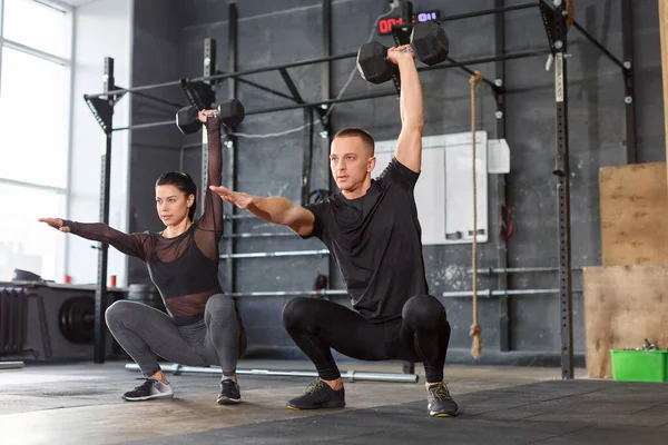 Çekici sporcular spor salonunda dambılları birlikte kaldırıyorlar. Sağlıklı yaşam tarzı kavramı.