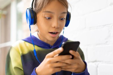 İnternette arkadaşlarıyla sohbet ederken mavi kulaklıklı bir genç kızın fotoğrafını çek..