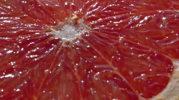 Close-up: half a grapefruit. Top view of a spinning fruit. — Stock Video