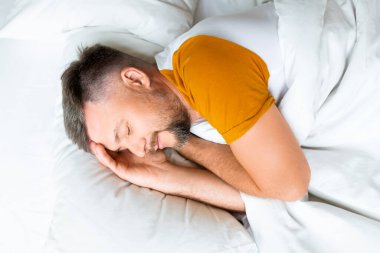 Uyuyan orta yaşlı bir adam. Sağlıklı uyku ve iyileşme kavramı.
