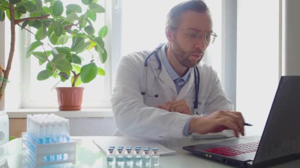 Arbeit in einer modernen Klinik. Der Arzt verarbeitet Patientendaten und macht Notizen im Journal. — Stockvideo