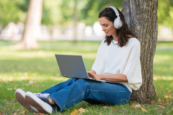 Portrait d'une femme de 40 ans avec ordinateur portable dans le parc de la ville lors d'un appel vidéo en ligne. Concept de travail en ligne ou concept d'enseignement en ligne à distance. — Photo
