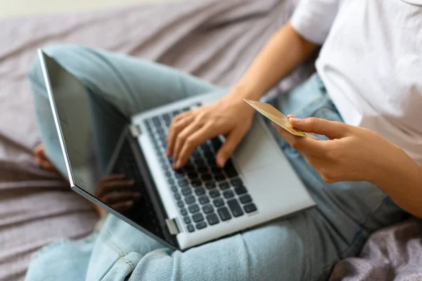Visão superior de uma mulher com cartão de crédito em mãos na frente do monitor de laptop. — Fotografia de Stock