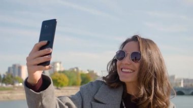 Genç bir kadın çevrimiçi video görüşmesi yapıyor. Sokakta akıllı telefonuyla video görüşmesiyle konuşuyor..