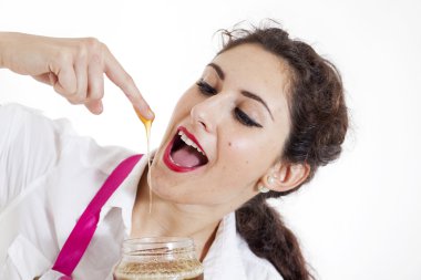 young pretty girl tasted honey from a finger
