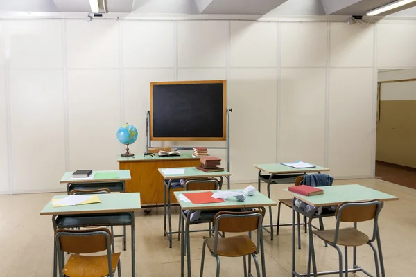 desks and blackboard in classroom at school