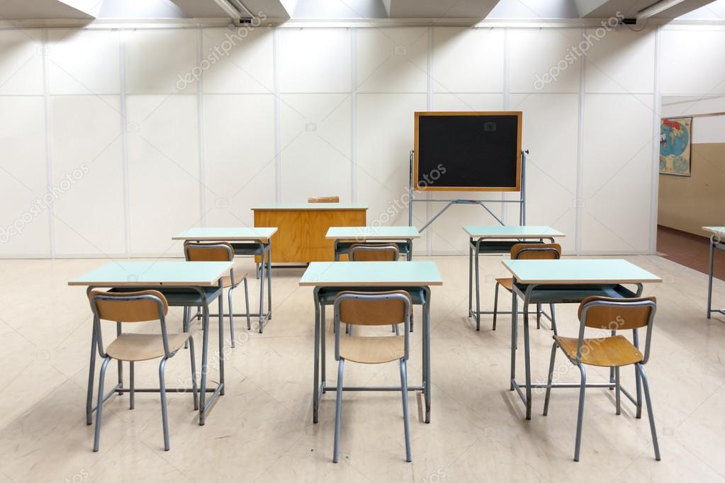 desks and blackboard in classroom at school