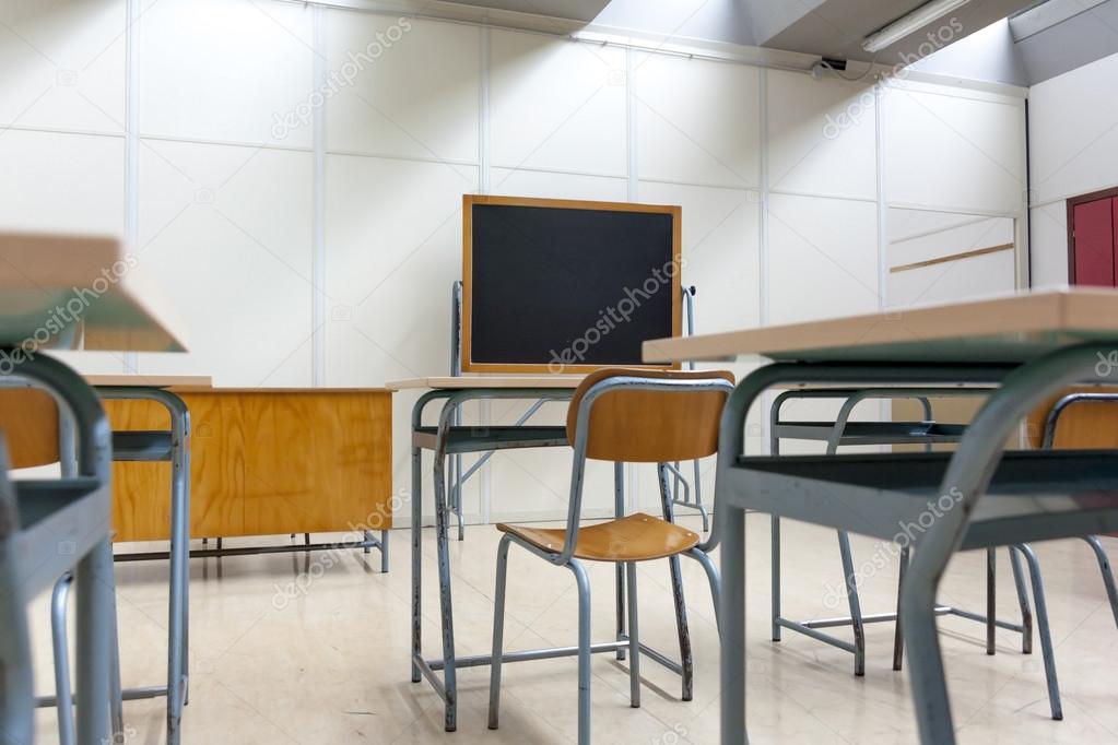 desks and blackboard in classroom at school