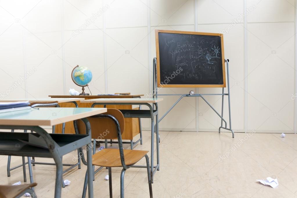 desks and blackboard in classroom at school