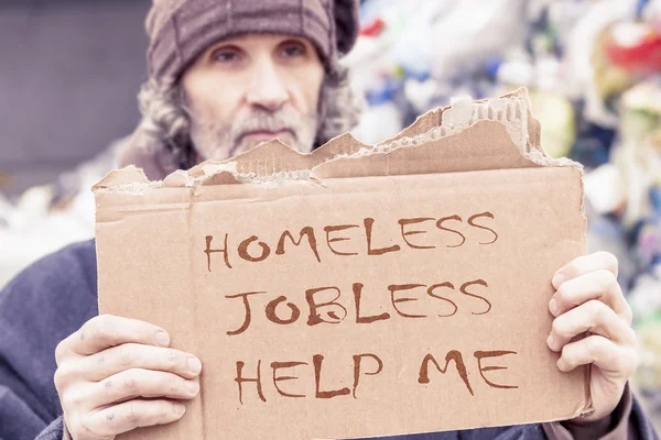 Obdachlose zeigen Hilfsbotschaft auf Pappe geschrieben — Stockfoto