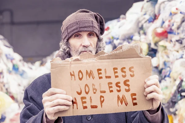 Άστεγοι δείχνουν ένα μήνυμα βοήθειας, γραμμένο σε ένα χαρτόνι — Φωτογραφία Αρχείου