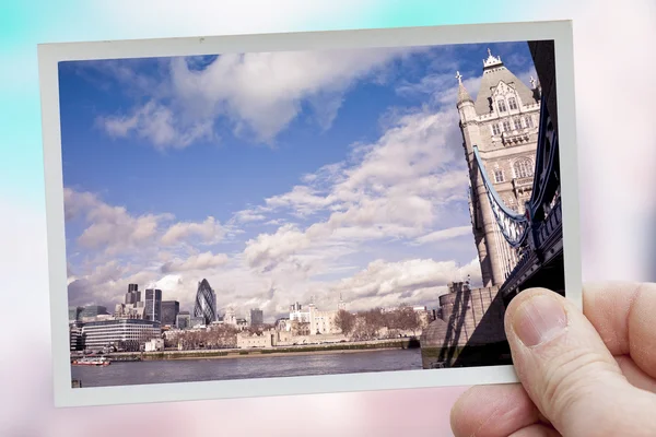 Hand holds snapshot of London on a blurred background — Stock Photo, Image